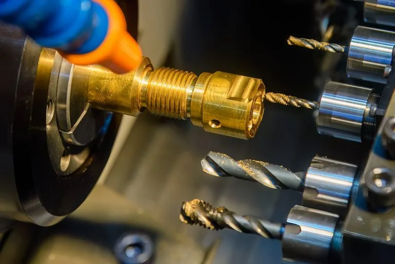 The  multi tasking CNC lathe machine swiss type drilling the brass fitting parts