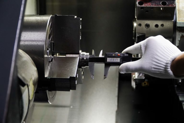 Quality control manufacturing,Engineer's hand measuring metal parts with digital vernier caliper,quality control of machined parts on lathe