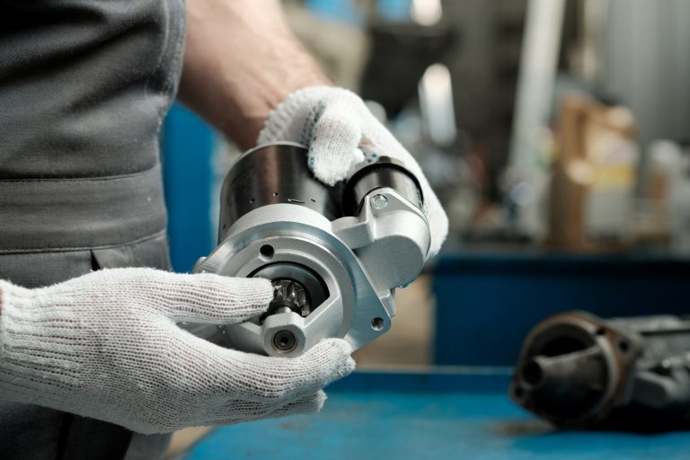 Spare parts.The car starter is in the hands of an auto mechanic.Installing a new and replacing a faulty starter.Maintenance and repair of the car in the service center