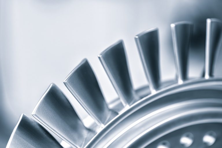 A close up of a turbine blade with a silver color. Concept of precision and engineering, as the blade is a crucial component of a turbine